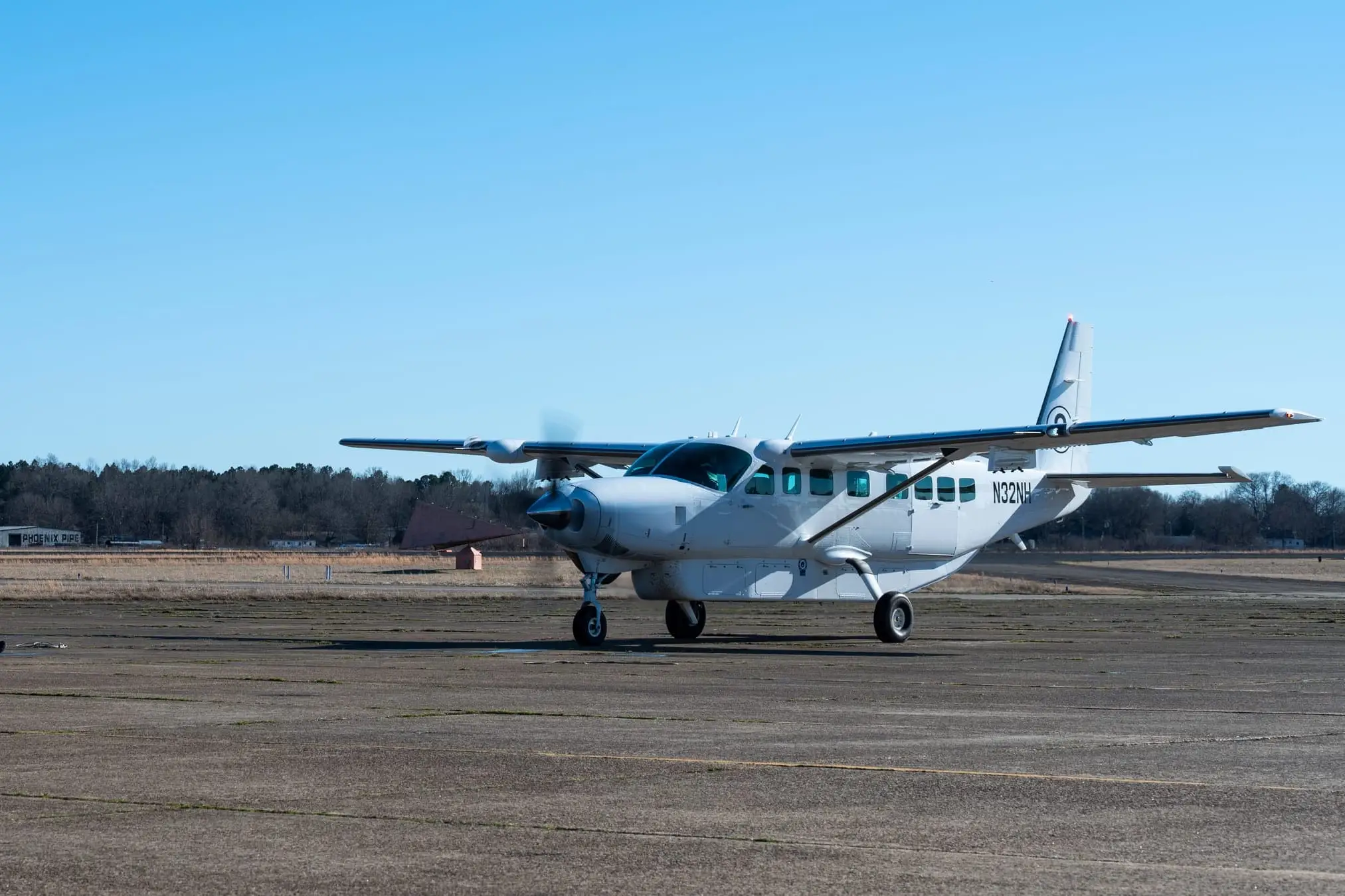 A Cessna Caravan in a surveillance fit on a bare concrete ramp