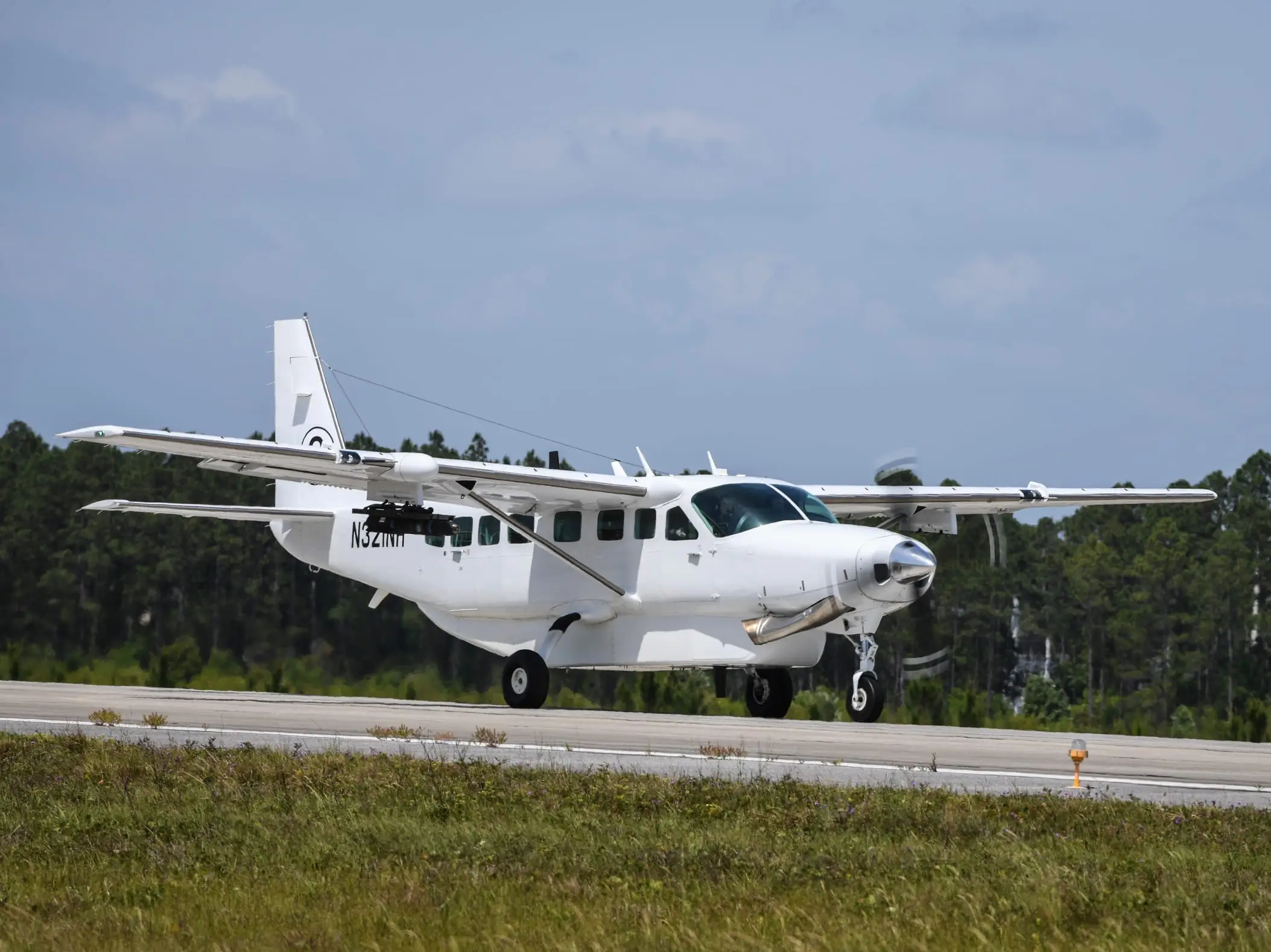 A Cessna Caravan on takeoff roll with a sensor turret under the forward fuselage