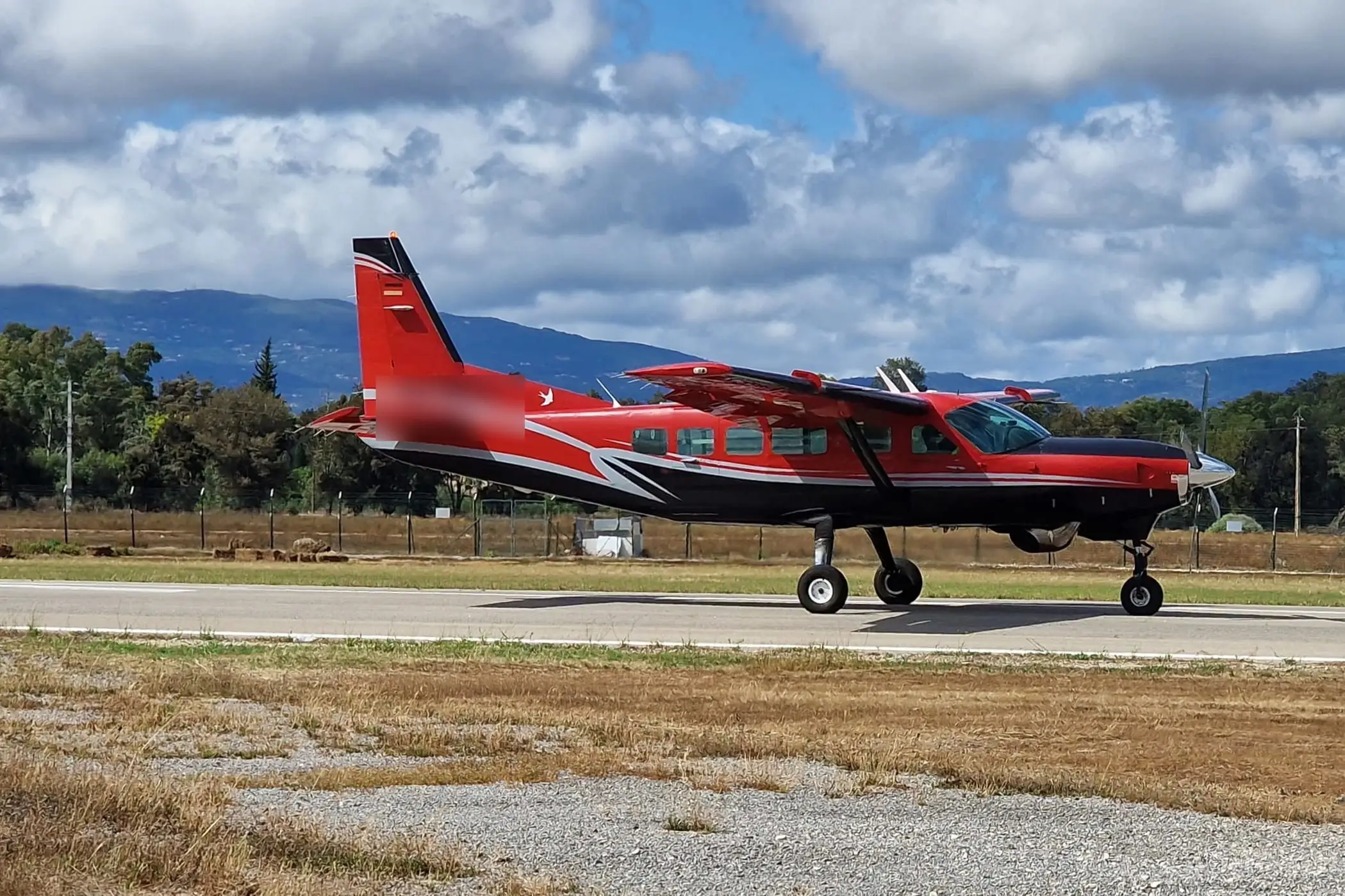 A Cessna Caravan taxiing on a rural airfield