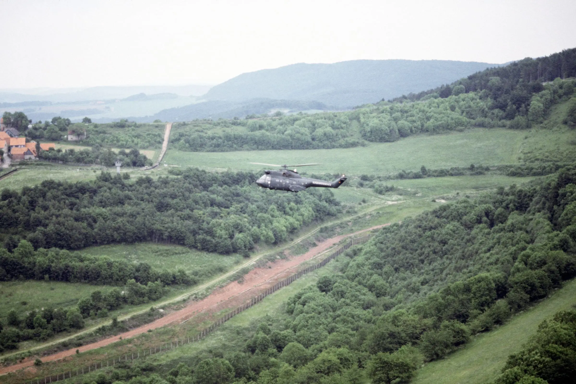 A light aircraft over broken valley terrain