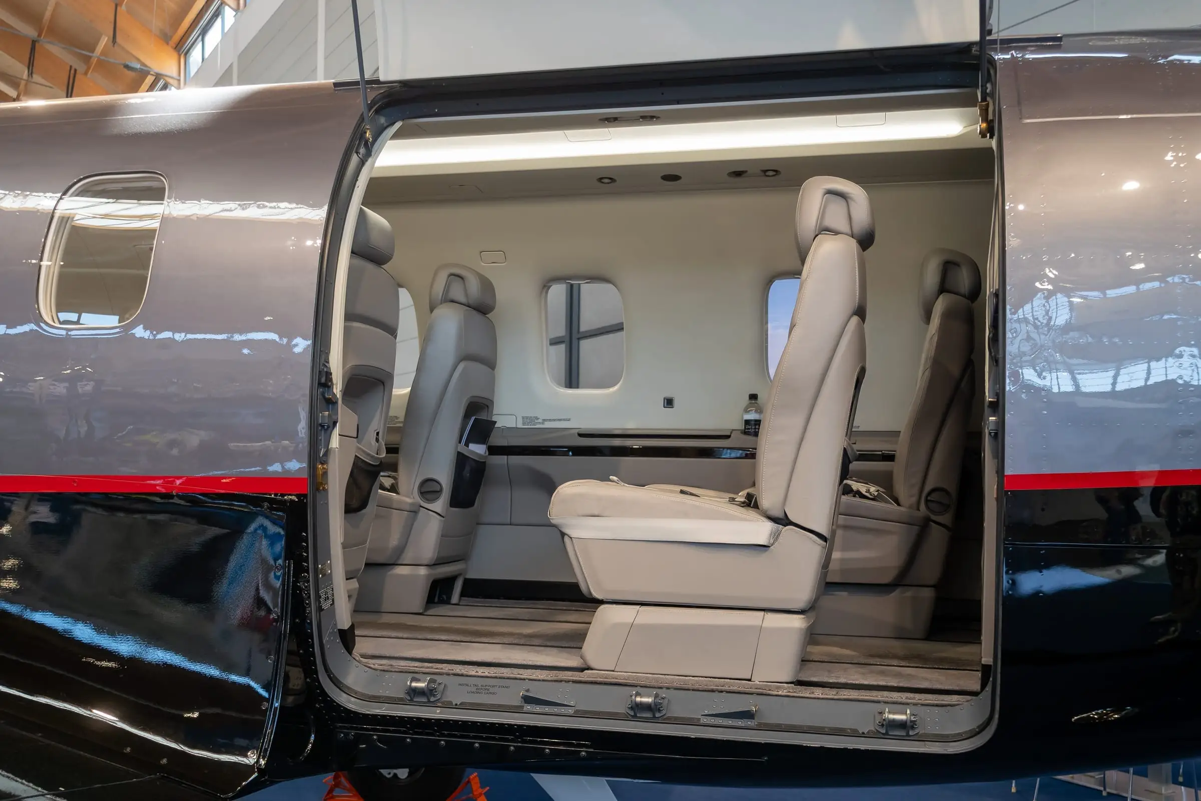 A PC-12 with its cargo door open showing the cabin