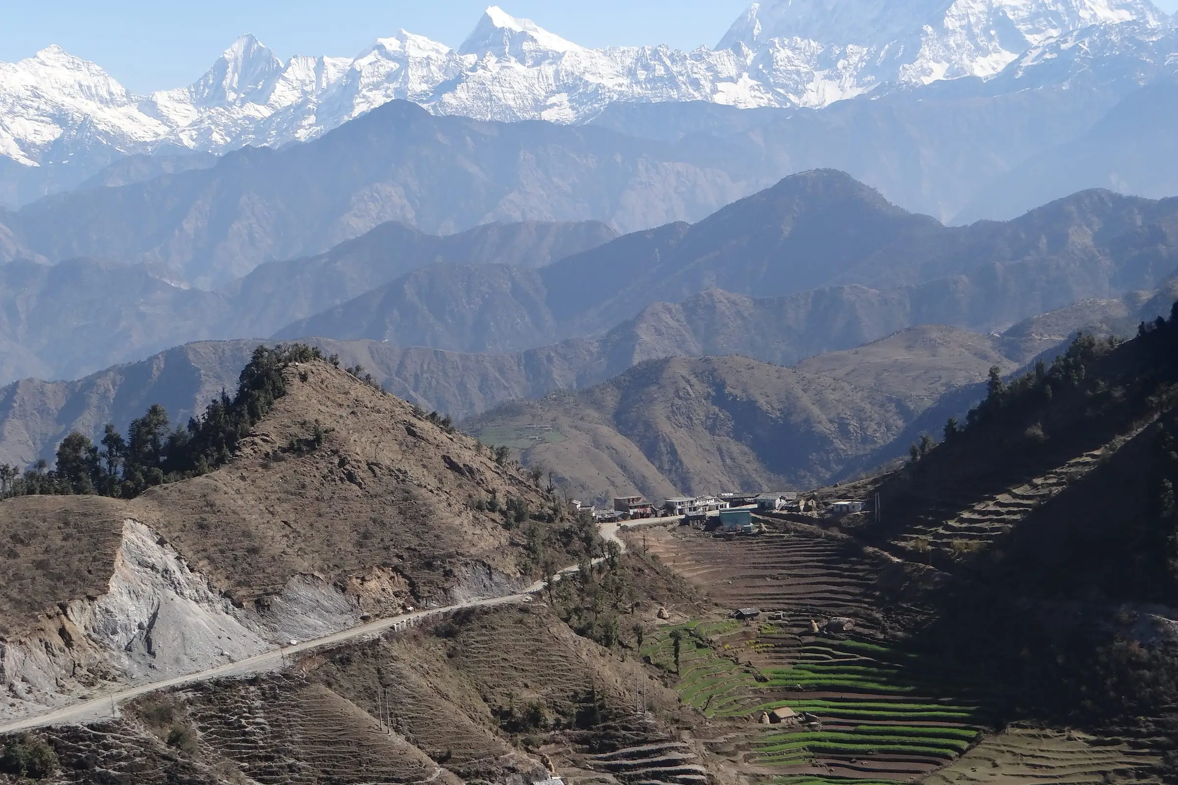 Successive mountain ridgelines receding toward a snow-covered range