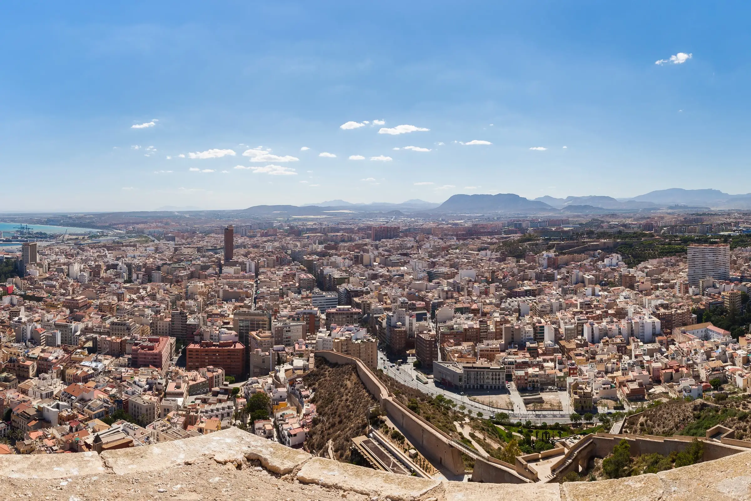 A dense Mediterranean port city seen from above with the harbor beyond