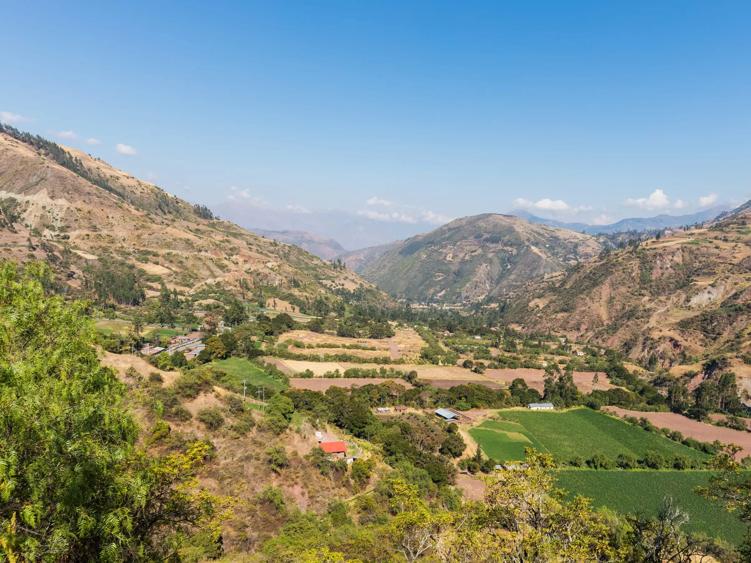 A high Andean valley with cultivated terraces on the slopes below bare ridgelines