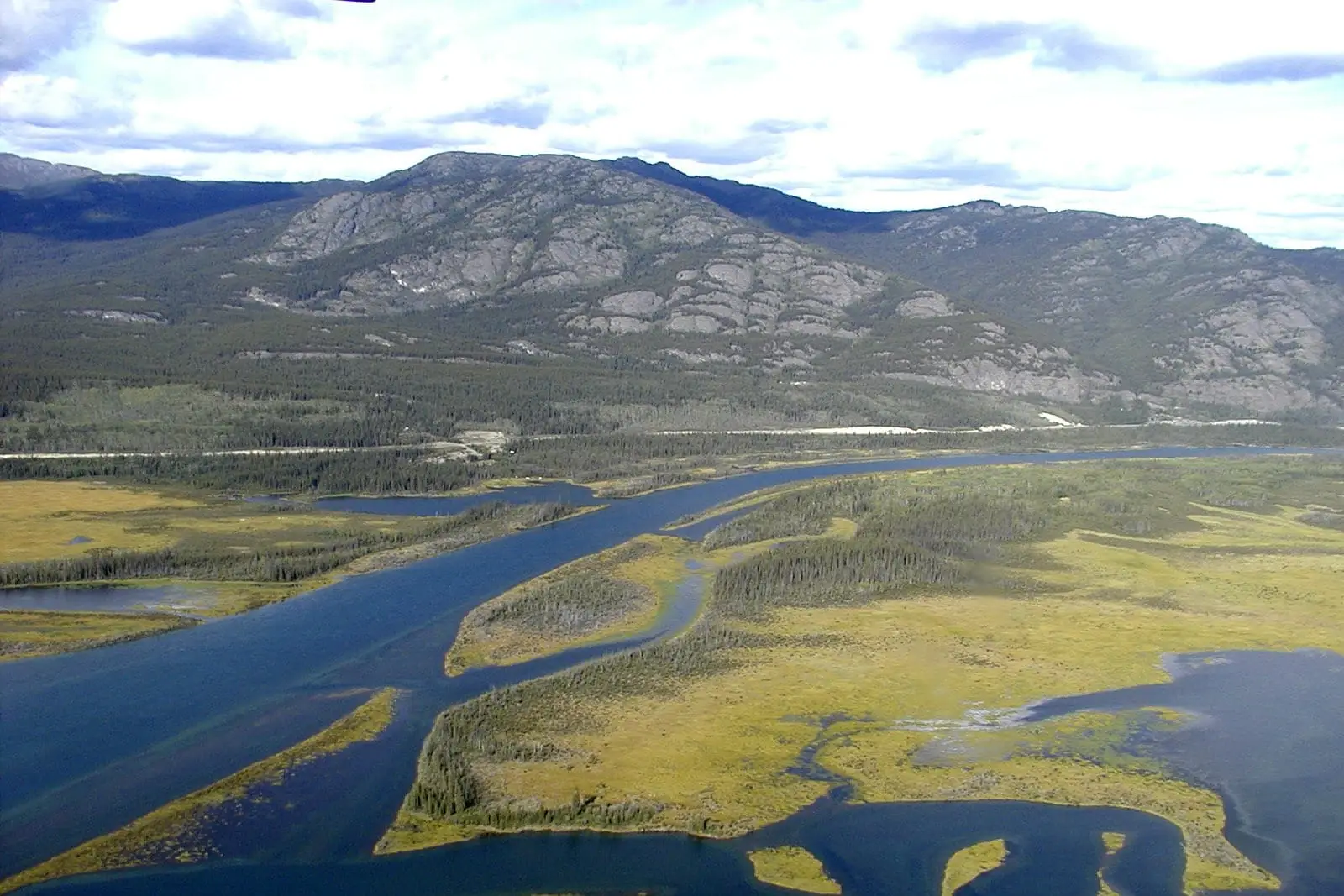 Braided river channels winding across a broad valley floor seen from the air